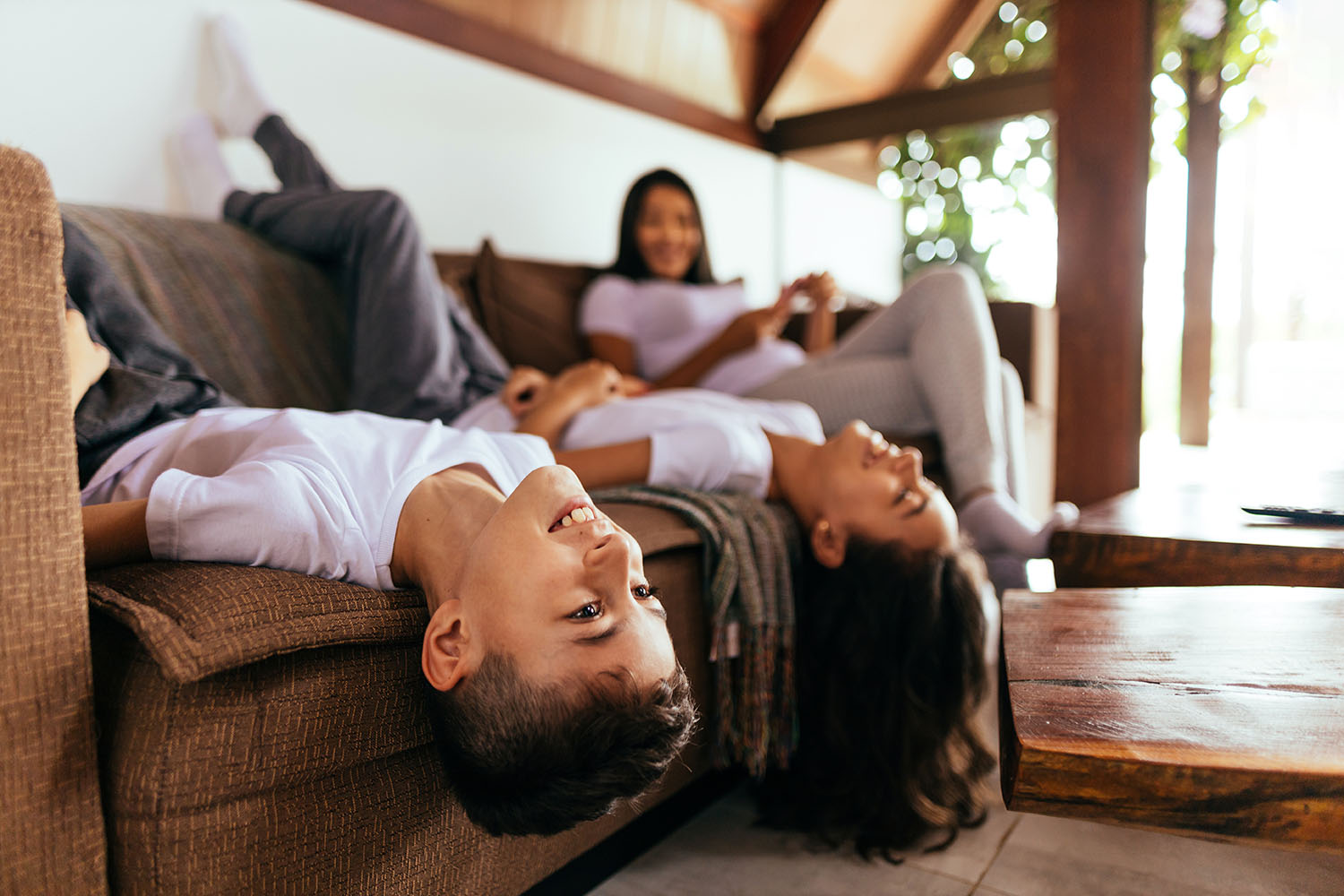 Happy brother and sister playing lying on the couch